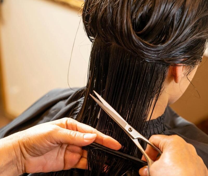 Professional stylist at Kate’s Kuts trimming hair to maintain healthy, strong strands.